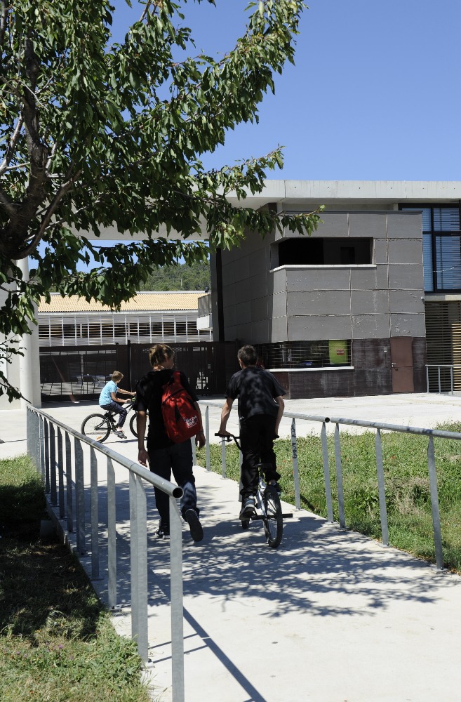 Des élèves, sac sur le dos, se rendent au collège à vélo et à pied. (Agrandir l'image)