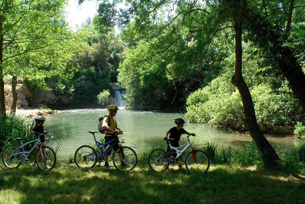 Trois personnes font du vélo devant une cascade (photo prise à Bras, dans le Var) (Agrandir l'image)